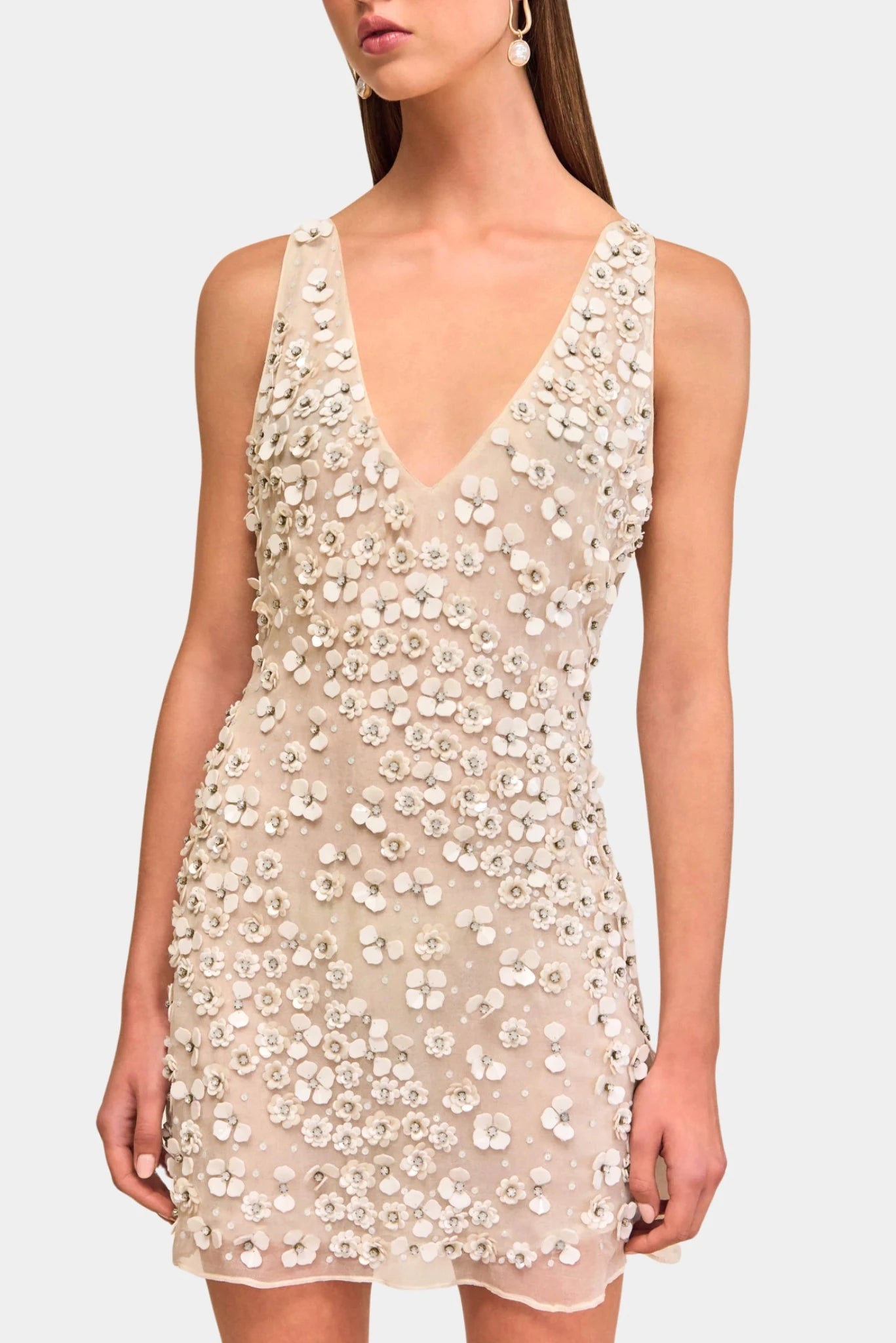 Detalhe de vestido nude com flores aplicadas e textura bordada tridimensional