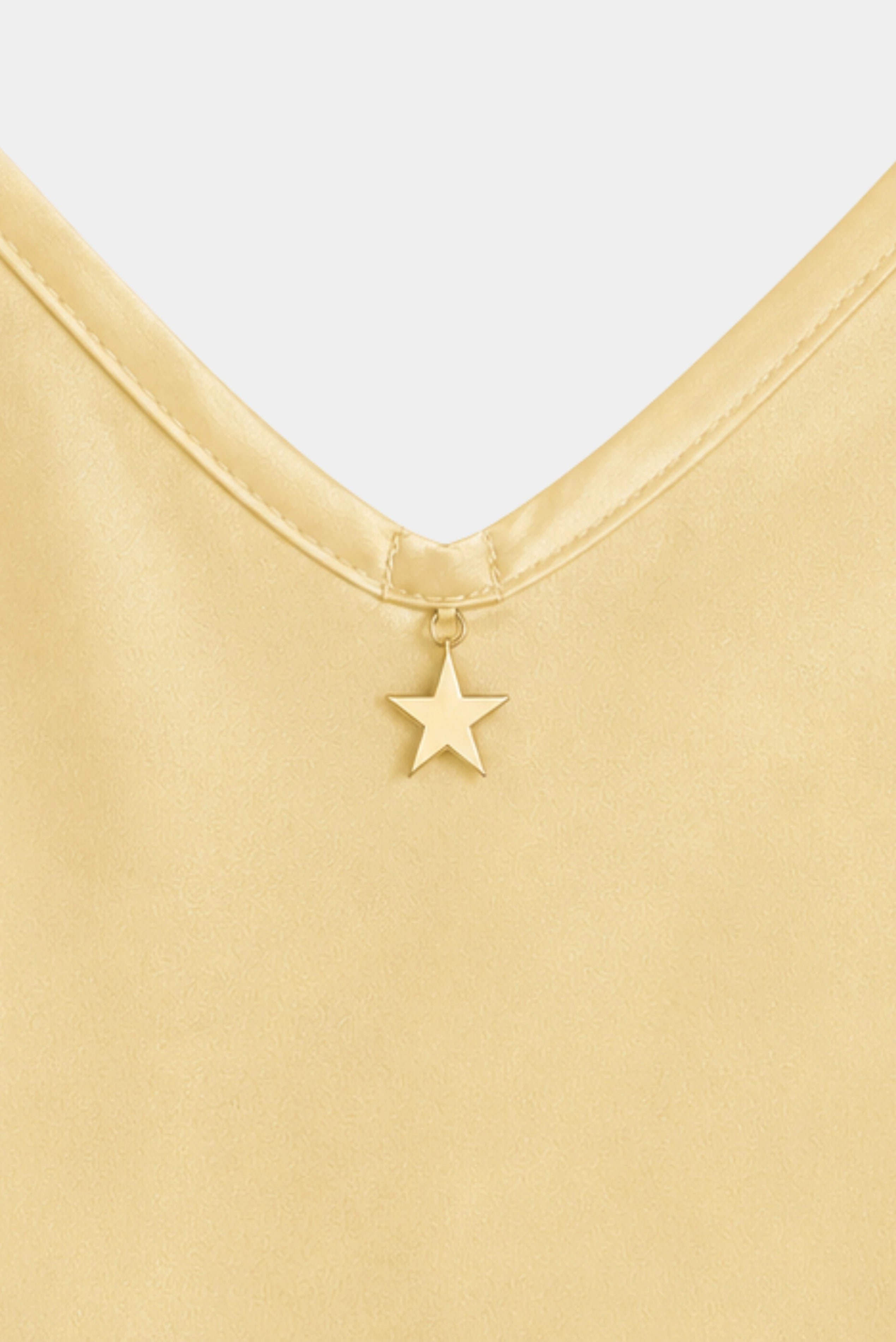 Detalhe do decote V com pingente estrela na Regata Lauren Gaia amarelo manteiga