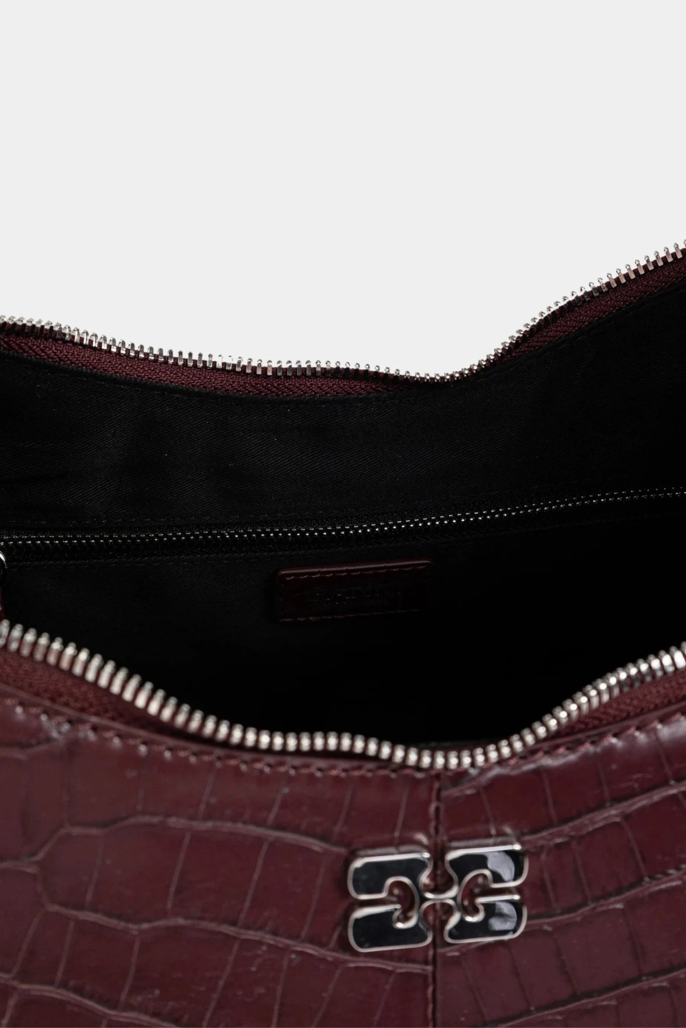 Detalhe interno da bolsa hobo Ganni com fechamento em zíper