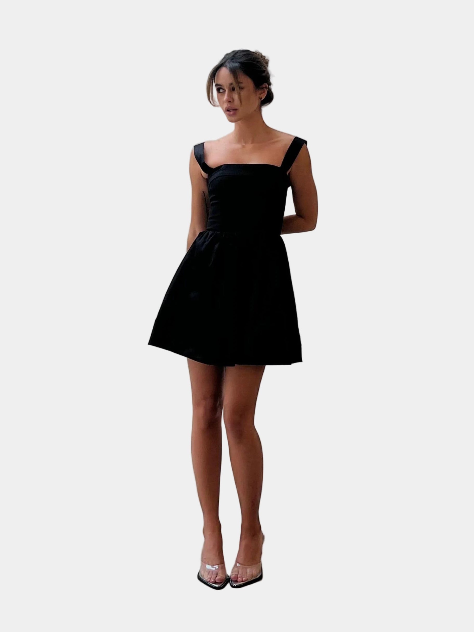 Modelo veste Vestido Curto Nico Gaia preto com decote reto e saia ampla