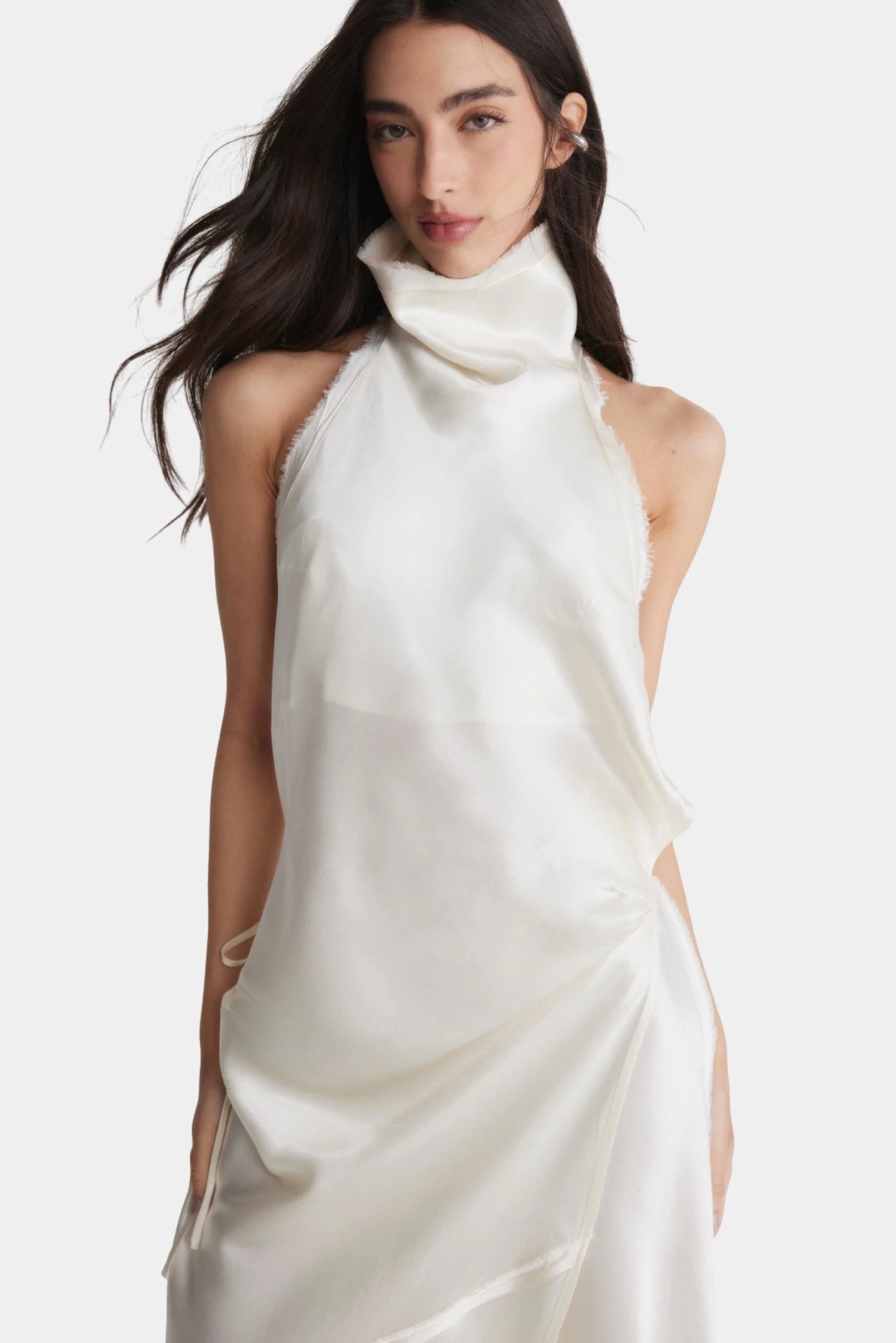 Detalhe do vestido fluido off-white com gola alta drapeada e acabamento assimétrico