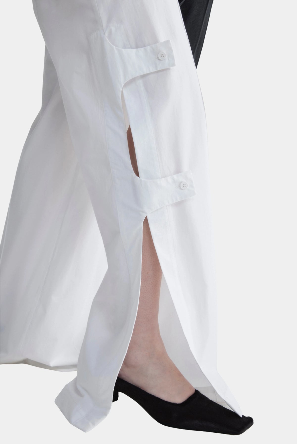 Detalhe da Calça Brut Francesca branca com abertura lateral e tiras abotoadas