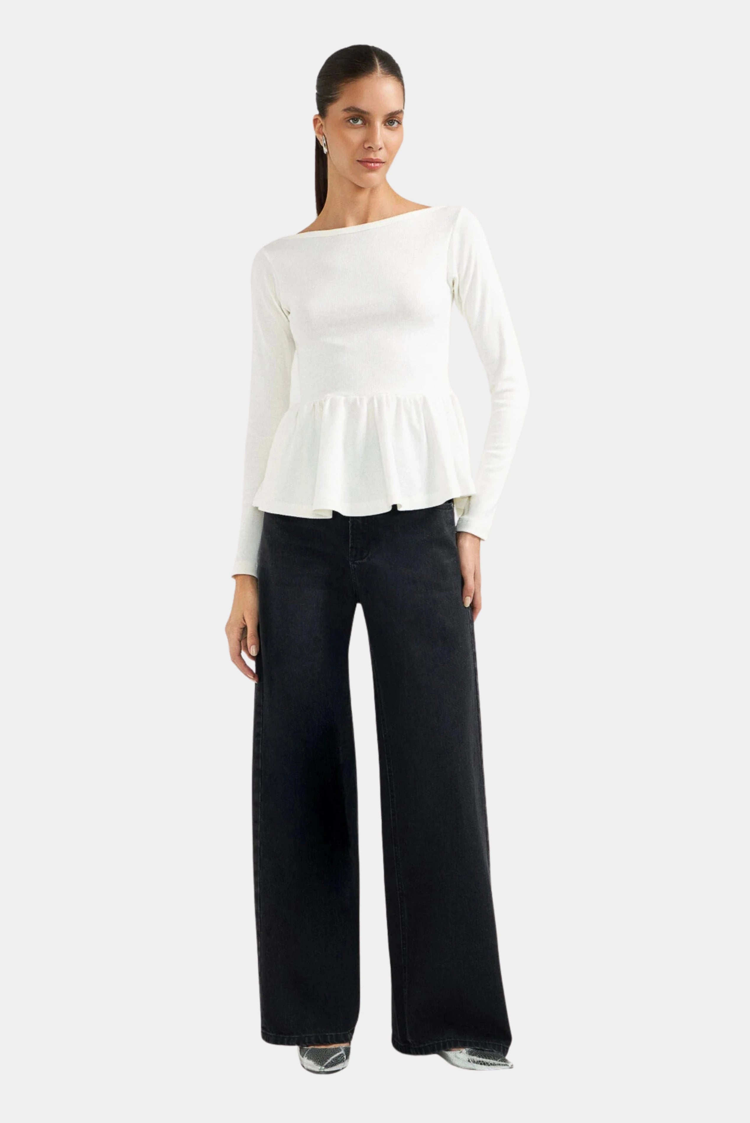 Modelo usando calça jeans wide leg escura de cintura alta e pernas amplas