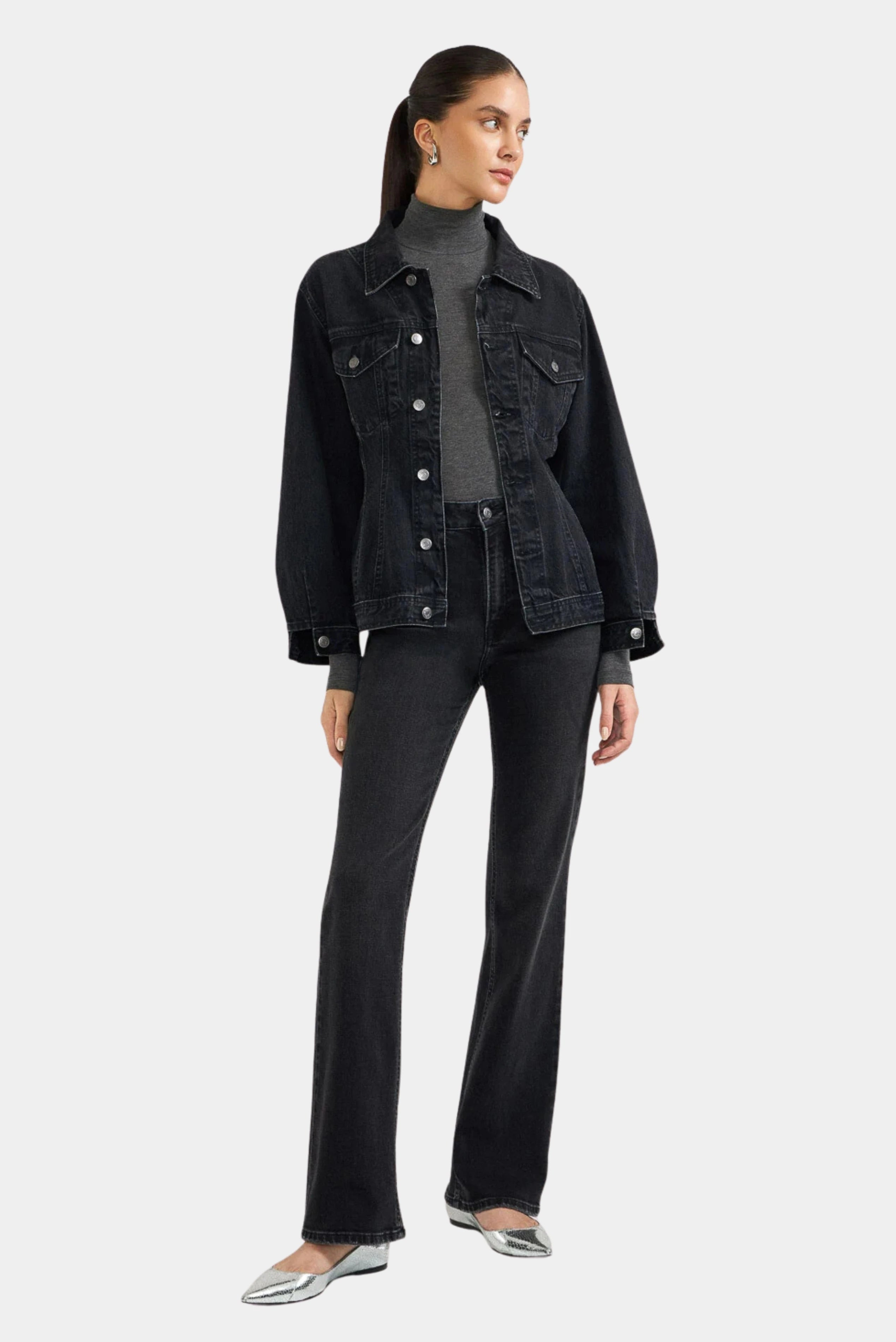 Modelo usando jaqueta jeans preta acinturada com calça jeans escura