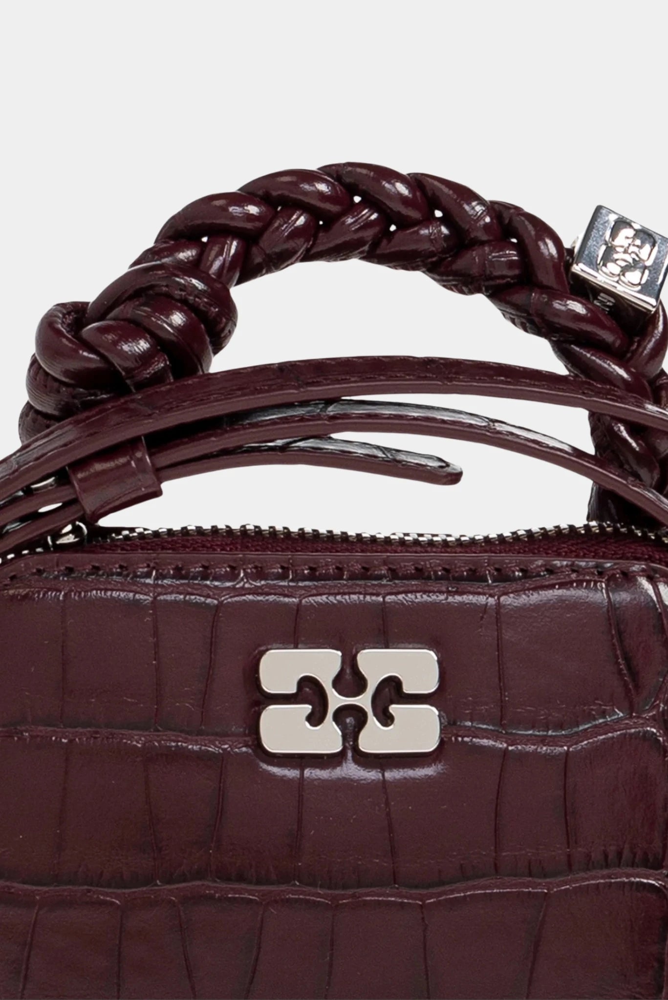 Detalhe da Bolsa Bou Nano Ganni bordô com alça trançada e logo metálico