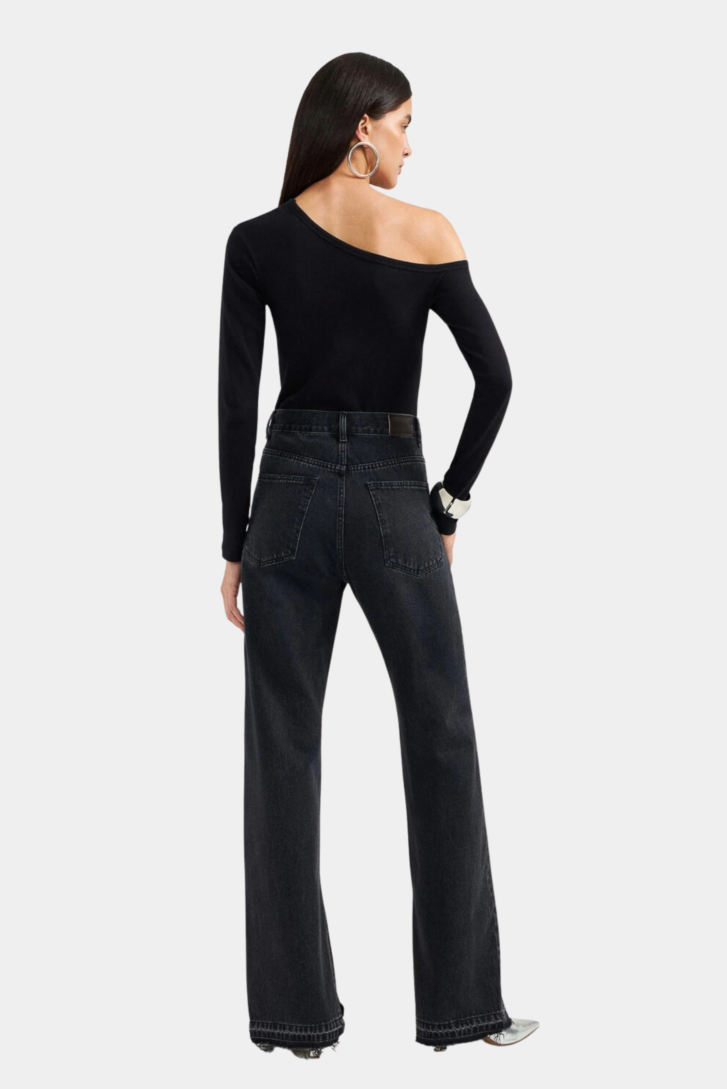 Modelo usando calça jeans 90s preta de cintura alta em vista traseira LDnim