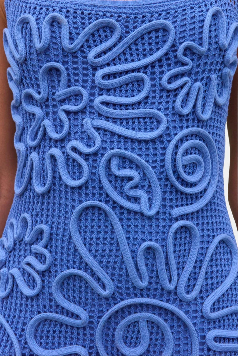 Detalhe do vestido Cult Gaia em crochê azul com padronagem floral tridimensional