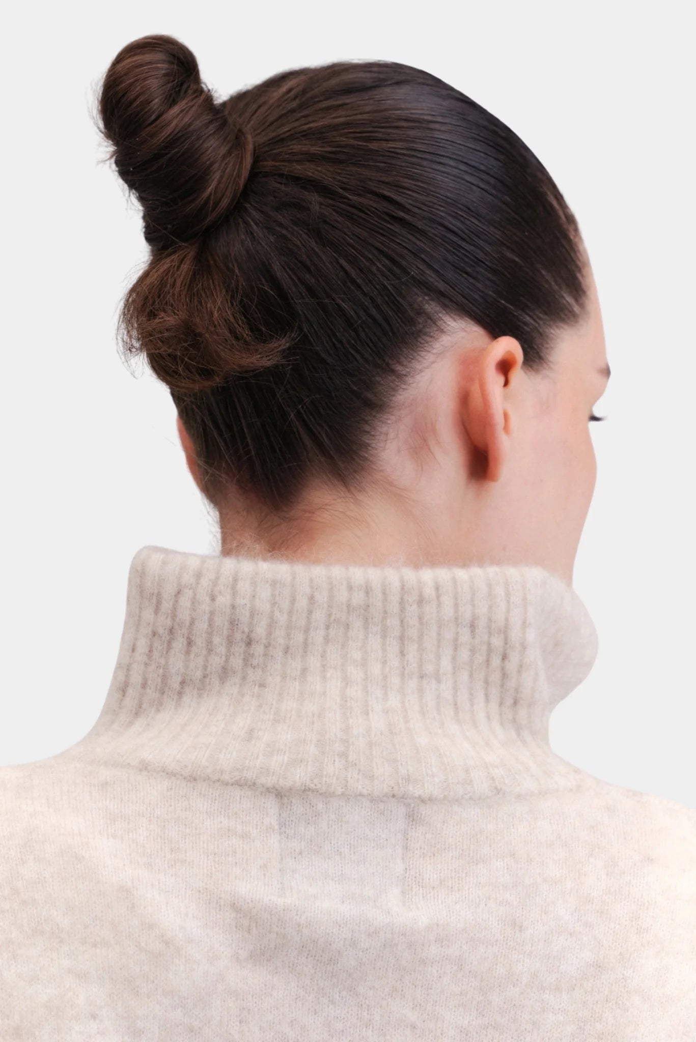 Detalhe da gola alta canelada do pullover oversized em tricot bege