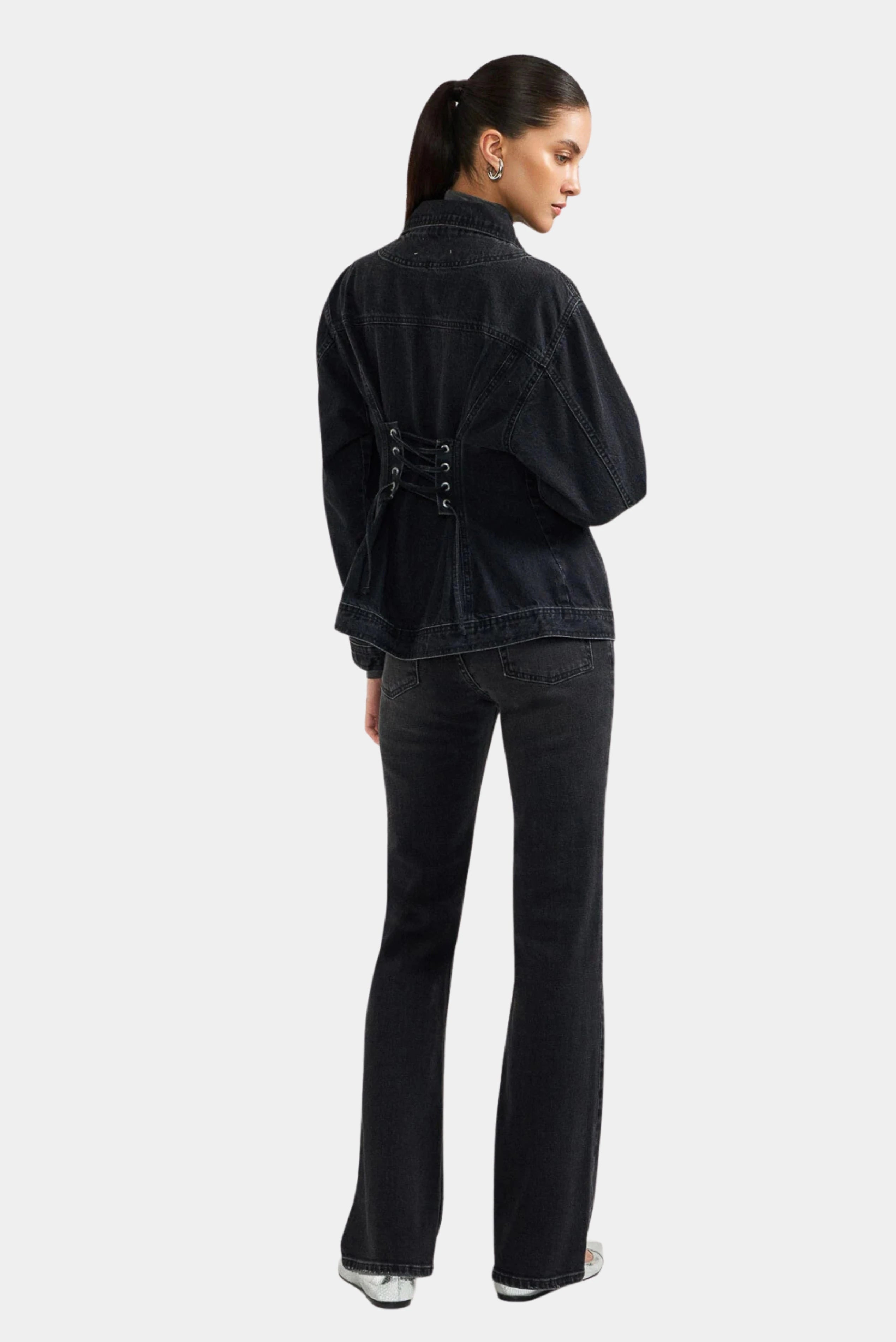 Jaqueta jeans preta com detalhe de amarração nas costas e modelagem ajustável
