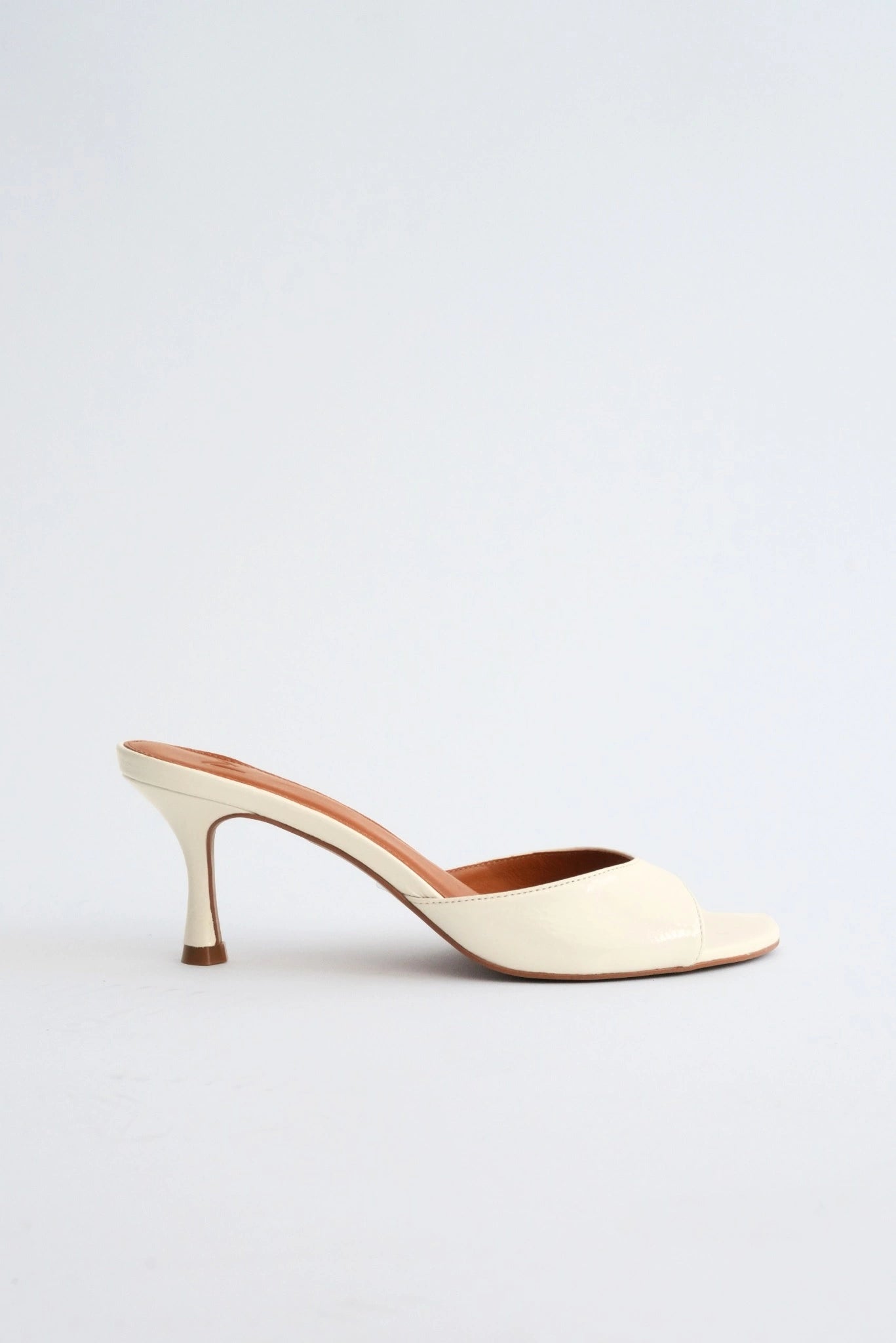 Sandália mule feminina off-white com salto médio escultural e design minimalista