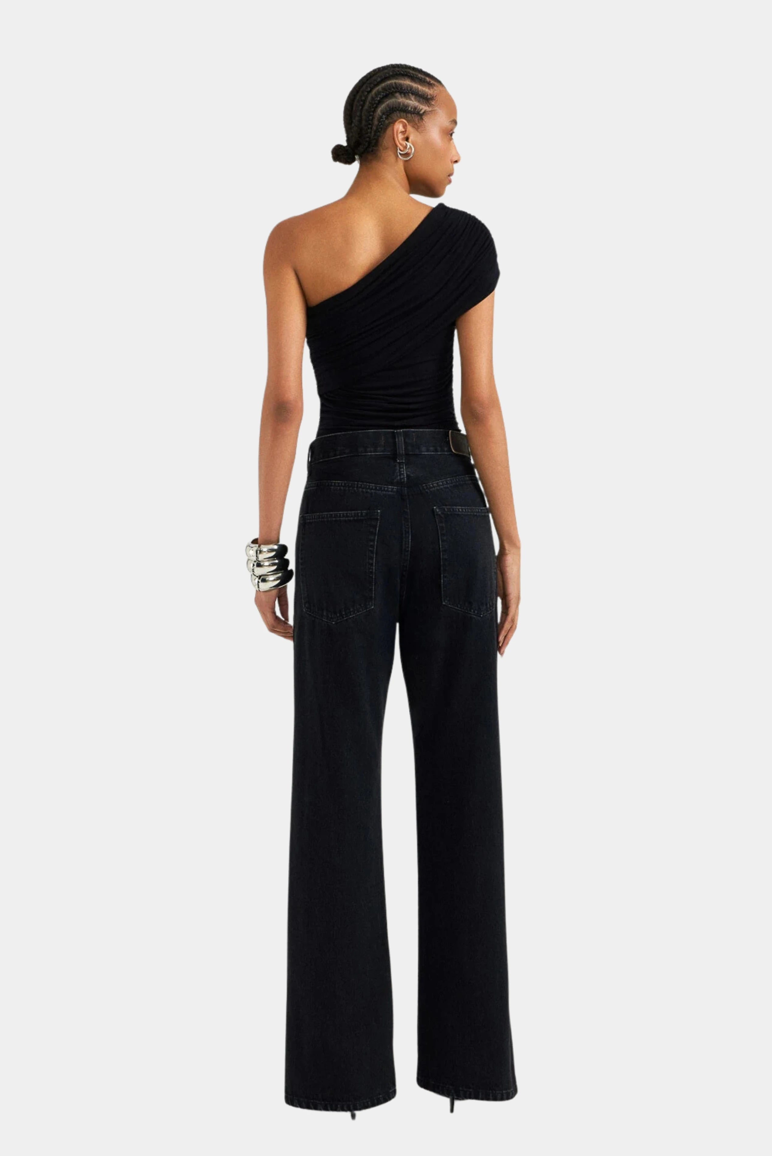 Calça jeans preta loose de cintura alta com botões laterais, vista traseira na modelo LDnim