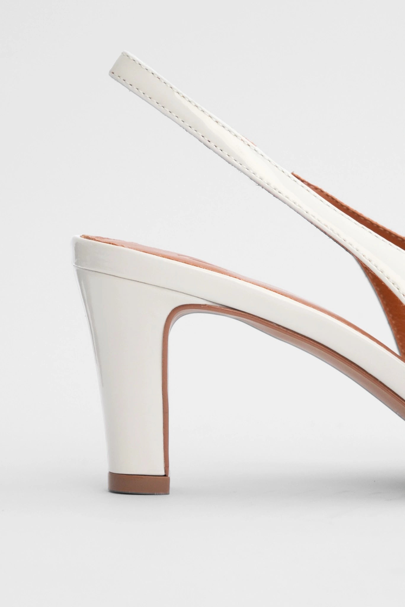 Close do salto médio com acabamento envernizado do Scarpin Slingback Paris MR off white