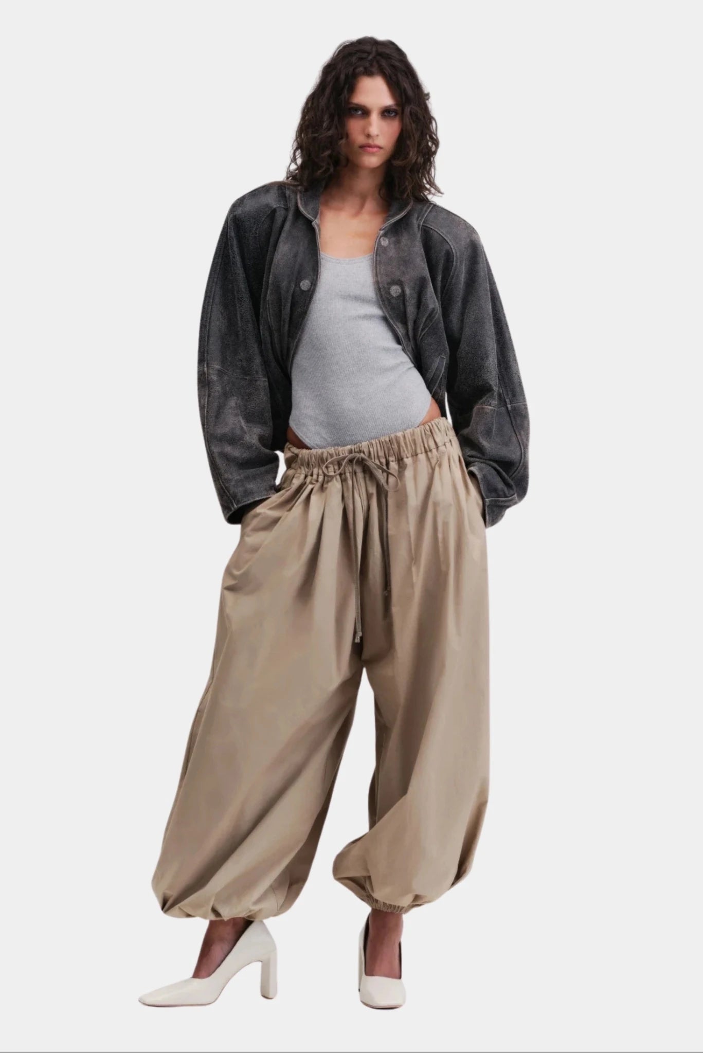 Calça off-white ampla com cintura elástica e barra franzida em look feminino contemporâneo