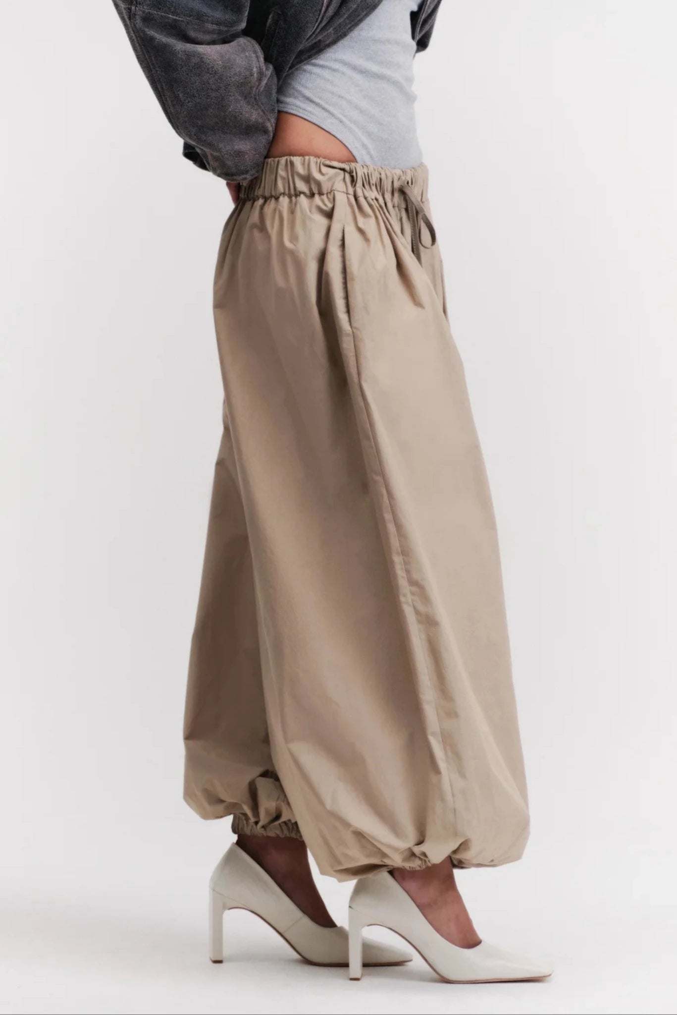 Detalhe da calça off-white com cós elástico ajustável e modelagem ampla