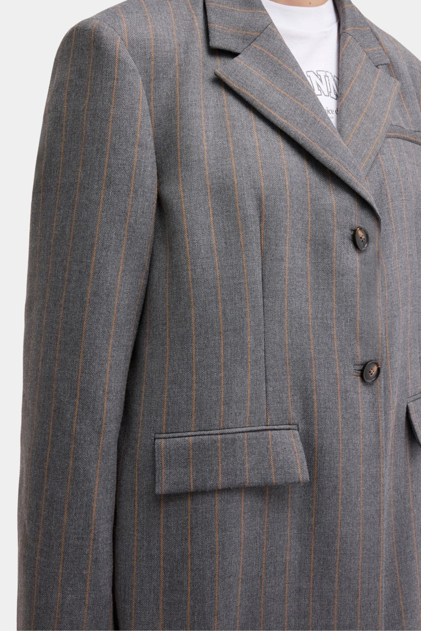 Detalhe do blazer Ganni cinza com padronagem risca de giz e lapela estruturada