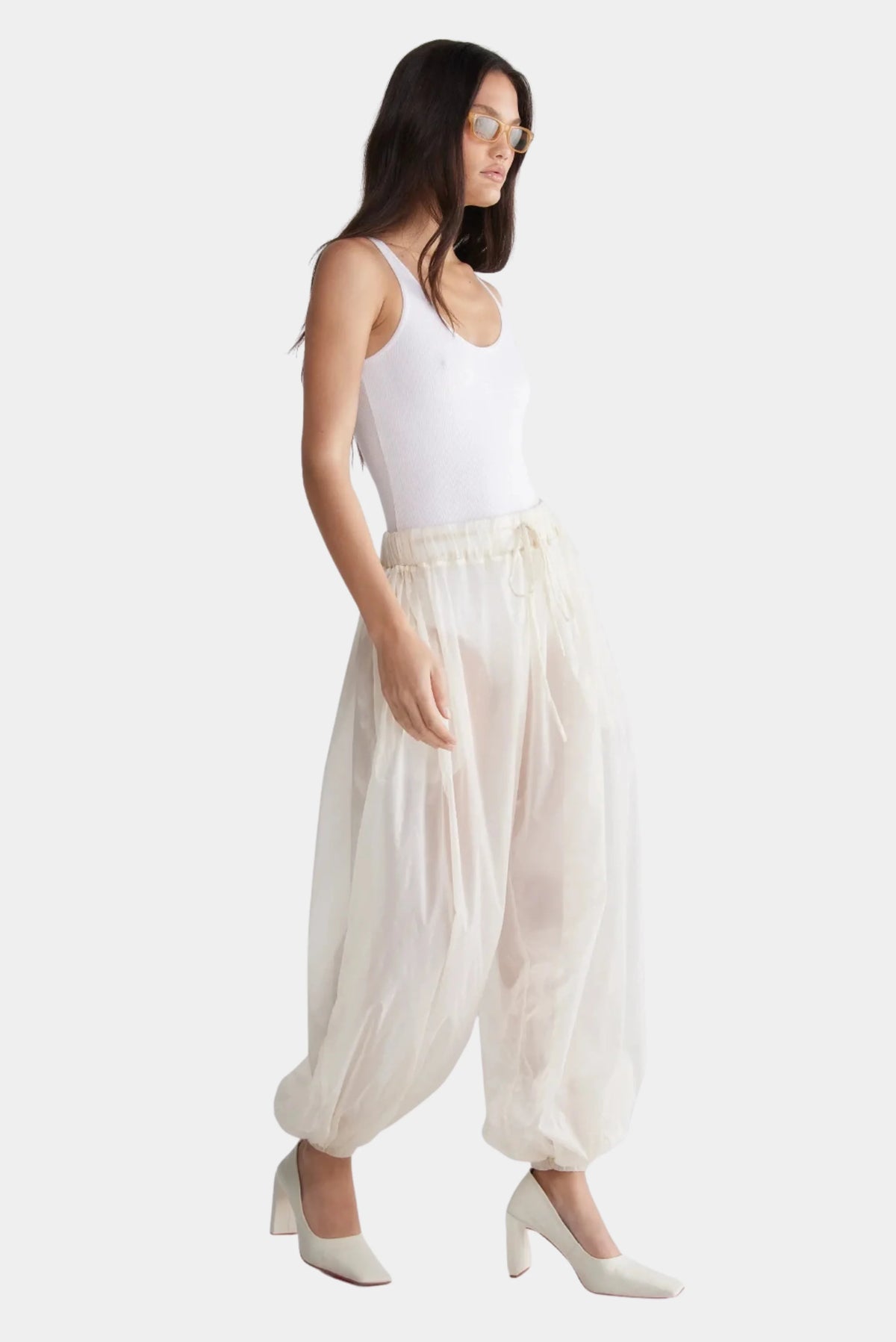 Calça Layer Francesca off-white translúcida vista lateral com pernas amplas e punhos