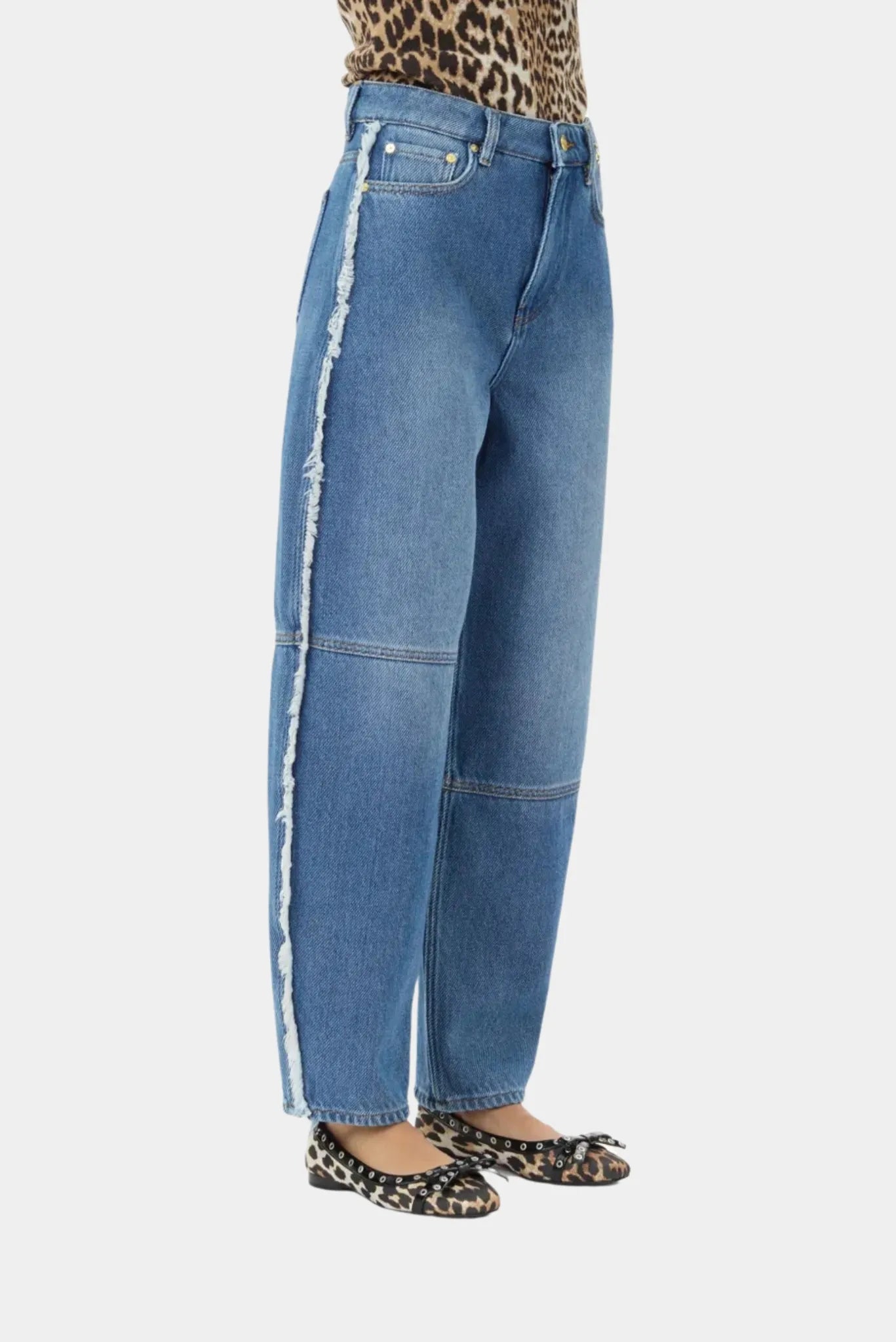 Detalhe da calça jeans Ganni azul com acabamento desfiado lateral e lavagem estonada