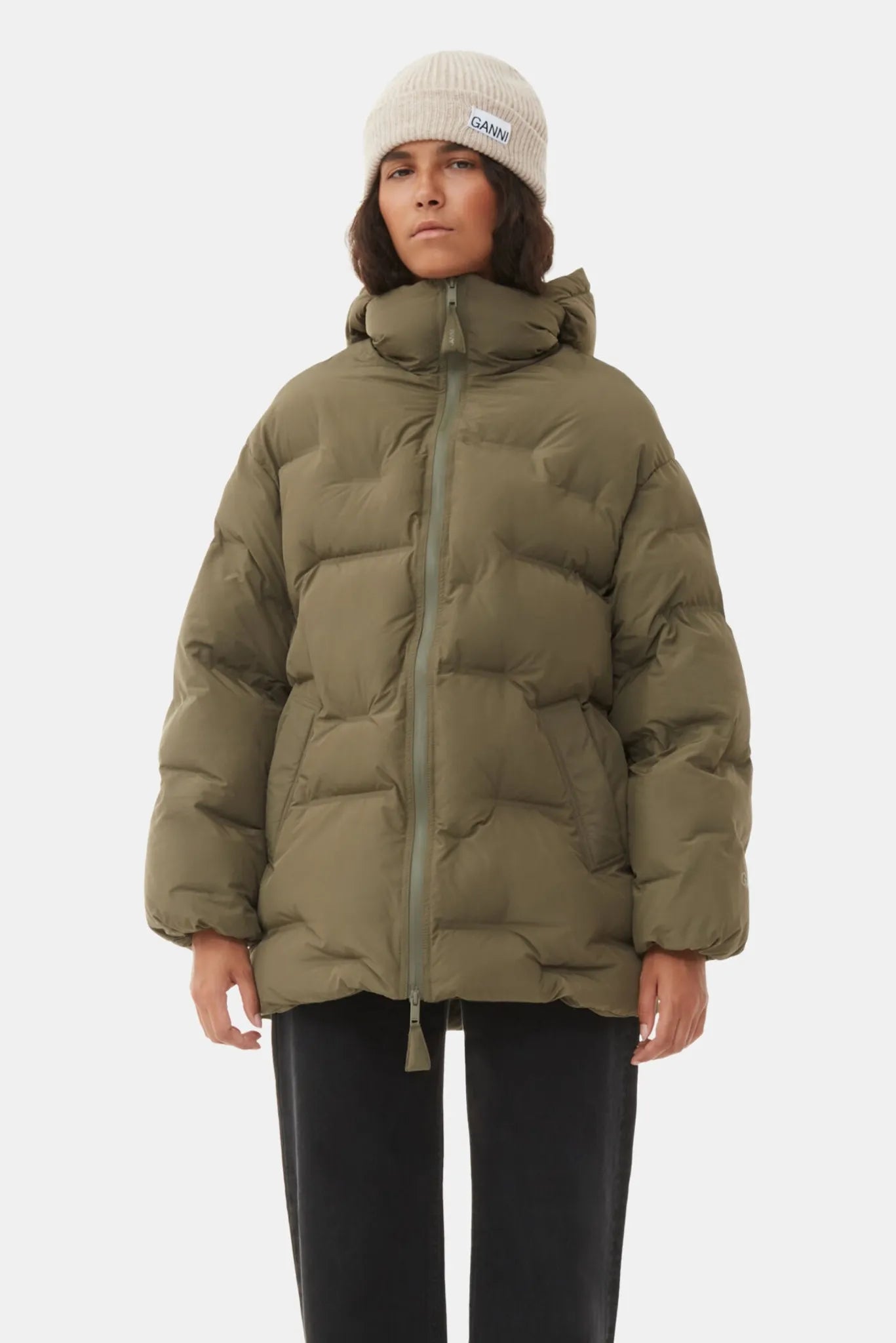 Gorro Ganni bege em tricô canelado usado com jaqueta puffer oversized