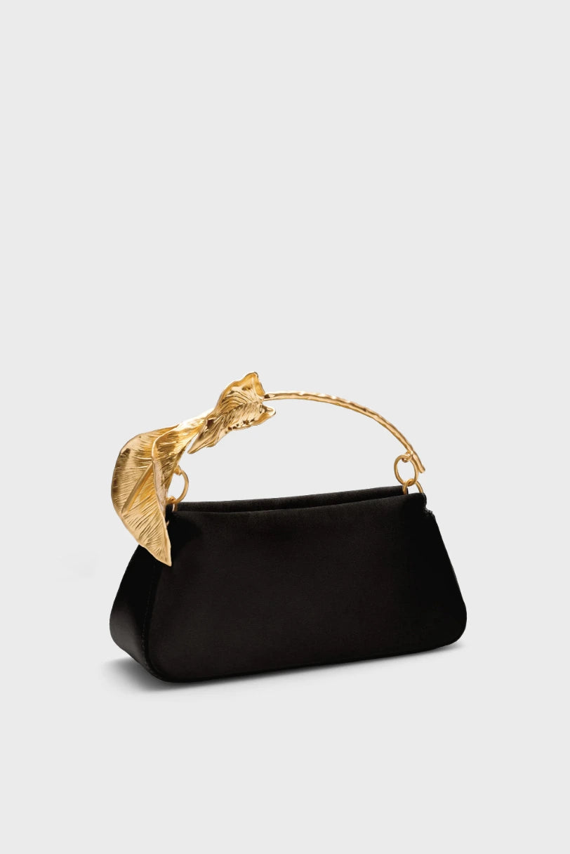 Bolsa Flor Calla Cult Gaia preta vista em angulo com a alca escultural dourada