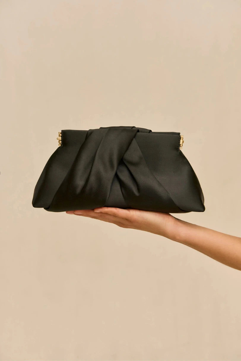 Modelo segurando a Bolsa Lia Cult Gaia preta de cetim na mao