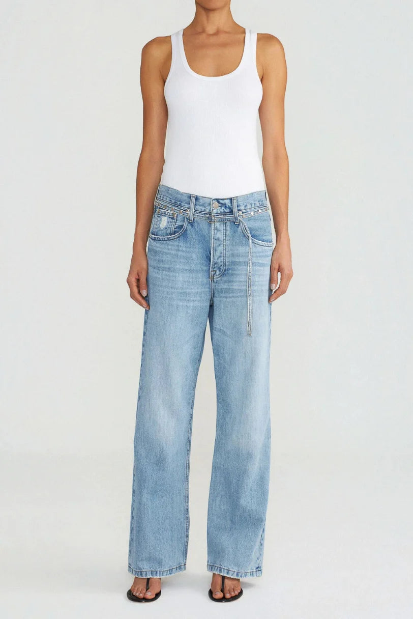 Modelo usando calça loose jeans vintage LDnim com cinto no mesmo tecido, vista frontal