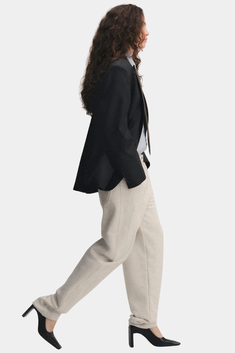 Calça Nor Francesca bege em look completo, vista de perfil