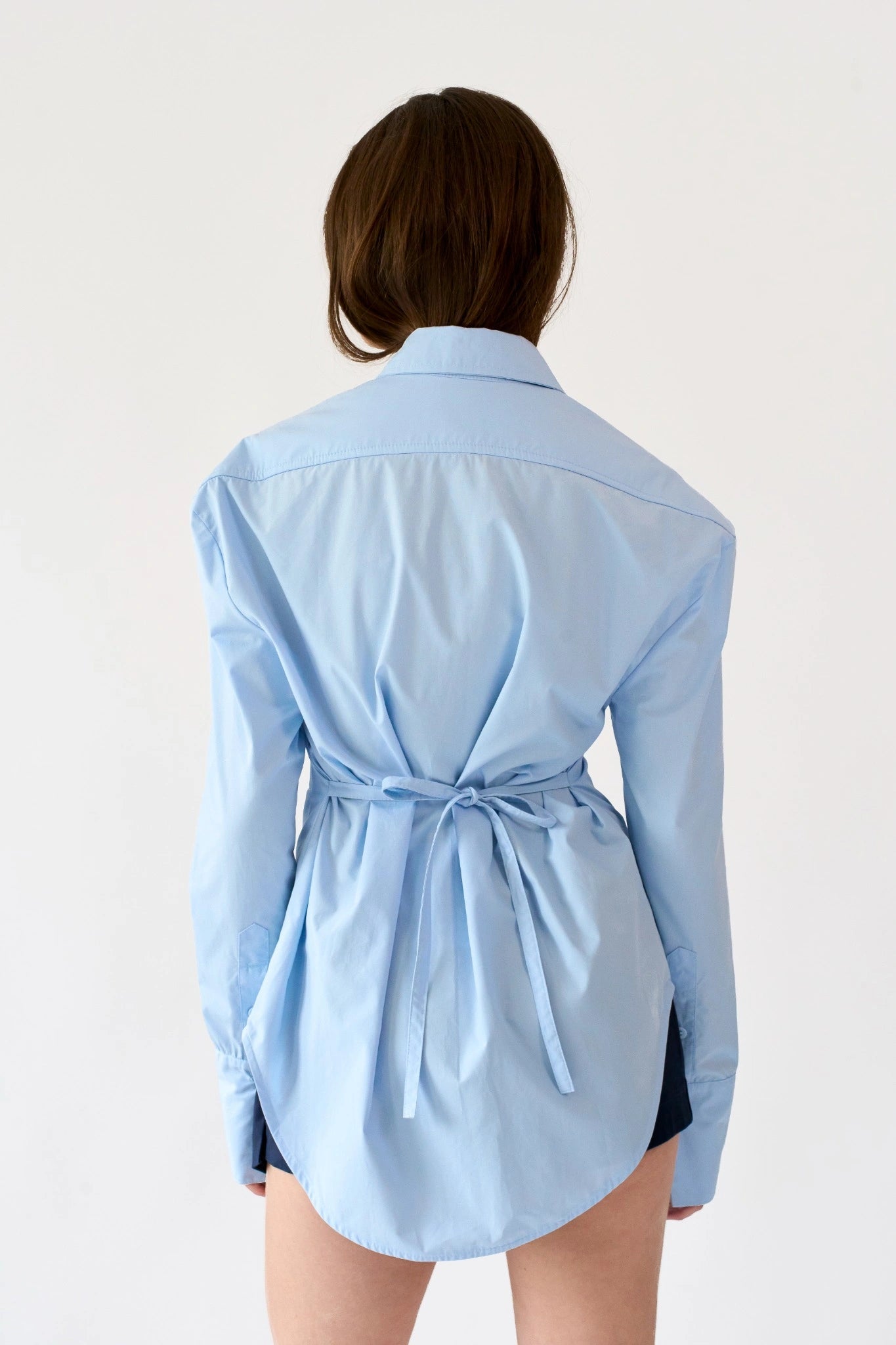 Detalhe da camisa Yuka MR azul-claro em tricoline com recorte ajustado na cintura