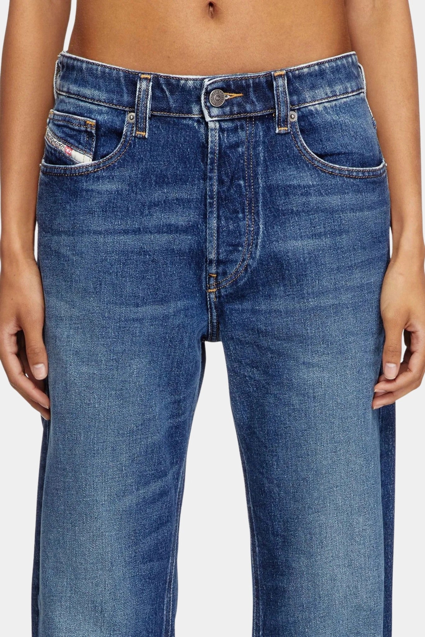 Detalhe frontal de calça jeans azul Diesel com cintura baixa e lavagem desgastada